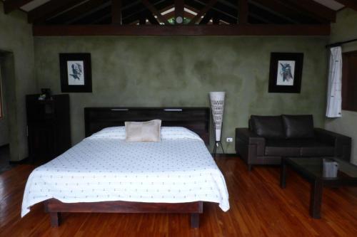 a bedroom with a bed and a couch at Tenorio Lodge in Bijagua