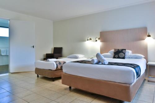 a hotel room with two beds in a room at Coffs Windmill Motel in Coffs Harbour