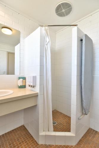 a bathroom with a shower and a sink at Coffs Windmill Motel in Coffs Harbour