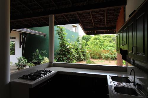 a kitchen with a stove top oven next to a window at Santori Unawatuna in Unawatuna