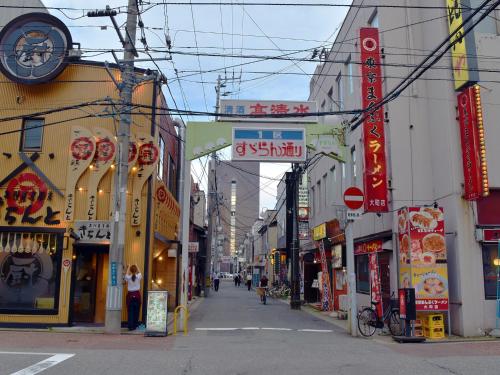 a street in an asian city with signs on buildings at Hotel Pearl City Akita Kawabata in Akita