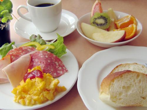 a white plate topped with breakfast foods next to a cup of coffee at Hotel Pearl City Akita Kawabata in Akita