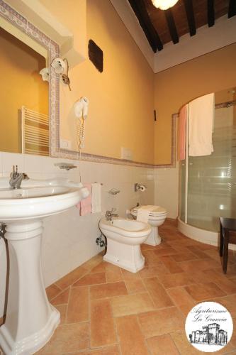 a bathroom with two sinks and a toilet and a shower at Agriturismo Castello La Grancia di Spedaletto in Pienza