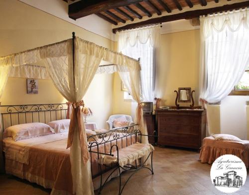 a bed room with a bed with a canopy over it at Agriturismo Castello La Grancia di Spedaletto in Pienza