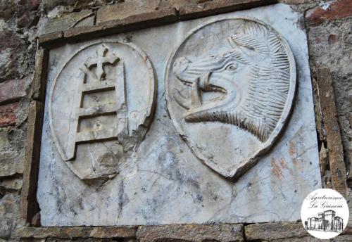 a stone wall with a statue of a lion with at Agriturismo Castello La Grancia di Spedaletto in Pienza