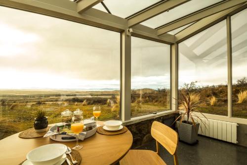 a dining room with a table and large windows at SkyScape in Twizel