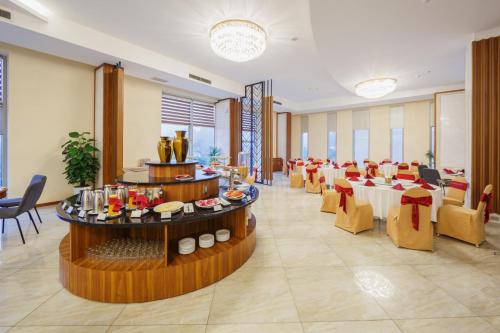 a dining room with tables and chairs in a restaurant at Muong Thanh Holiday Moc Chau Hotel in Mộc Châu