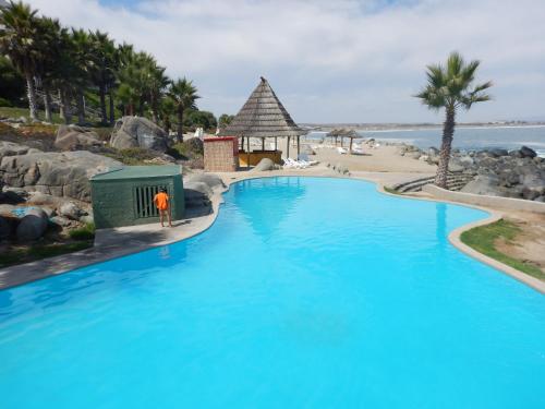 a man standing next to a swimming pool at a resort at Departamento Puerto Velero in Puerto Velero