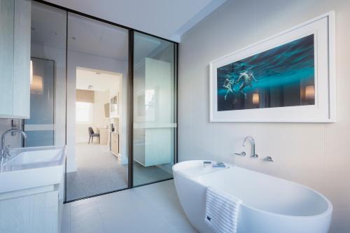 La salle de bains blanche est pourvue d'un lavabo et d'un miroir. dans l'établissement Spicers Potts Point, à Sydney