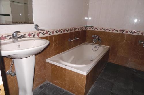 a bathroom with a sink and a bath tub at Hotel Span in Kozhikode