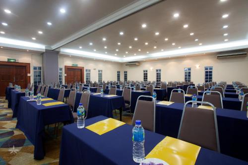 a large room with blue tables and chairs and water bottles at Hotel Seri Malaysia Johor Bahru in Johor Bahru