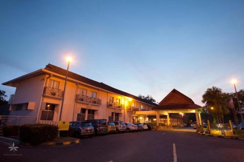 a building with cars parked in a parking lot at Hotel Seri Malaysia Alor Setar in Alor Setar