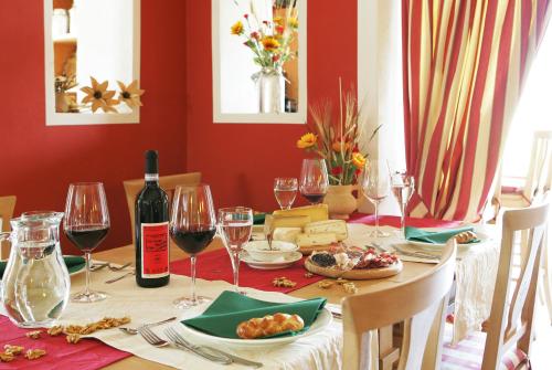 a dining room table with wine glasses and wine bottles at Agriturismo Stella Orobica in Albosaggia