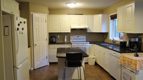 a kitchen with white cabinets and a black counter top at Brother Li Homestay in Calgary