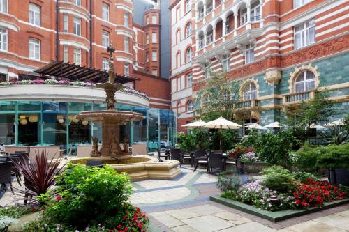 un patio con una fuente y sillas y edificios en Taj 51 Buckingham Gate Suites and Residences en Londres