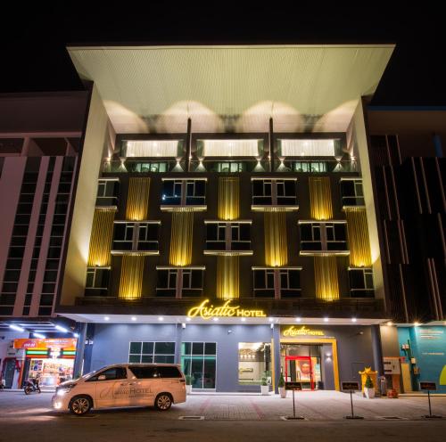 un coche aparcado delante de un edificio por la noche en Asiatic Hotel en Melaka