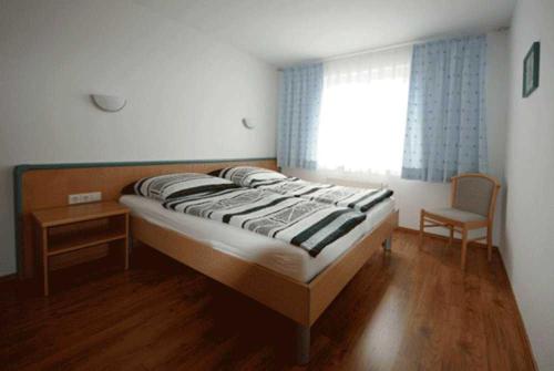 ビンツにあるFewo Binz Wohnpark Stadt Hamburgのベッドルーム1室(ベッド1台、椅子、窓付)