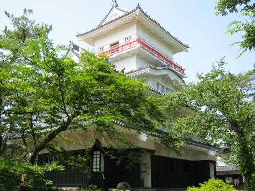 a tall white building with red trim at Hotel Pearl City Akita Kanto-Odori in Akita