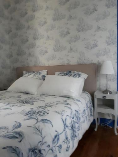 a bedroom with a bed with a blue and white comforter at Villa SAINT-PRIVAT in Pouzilhac