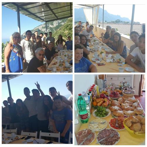 a group of people sitting at a table with food at Casa Falcone B&B in Scala