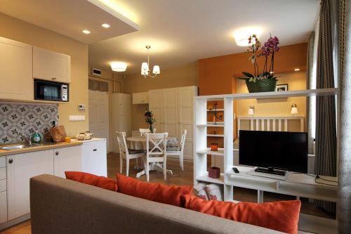 una cucina e un soggiorno con divano e TV di Orchidea Apartman Eger a Eger