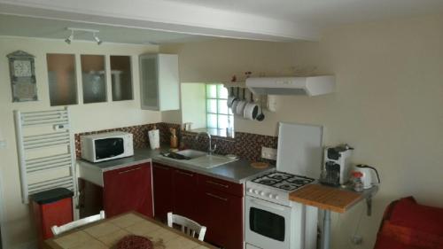 a kitchen with a white stove and a microwave at Appartement T1 in Dun-les-Places