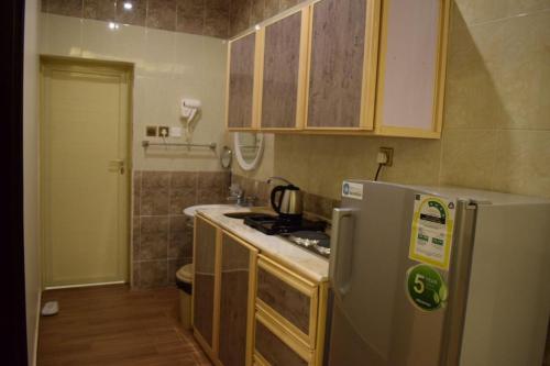 a kitchen with a refrigerator and a stove at Al Shiraz Suites in Muhayil