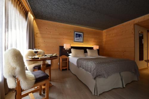 a bedroom with a bed and a table and a chair at Chalet-Hôtel La Chemenaz, The Originals Relais in Les Contamines-Montjoie