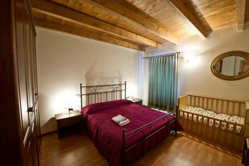 a bedroom with a red bed and a mirror at Agriturismo Della Pieve in Bardolino