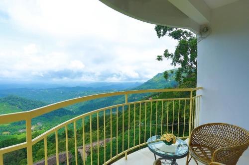 a balcony with a table and chairs and a view at The Cliff Resort, Munnar in Munnar