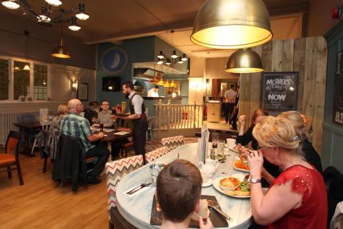 a group of people sitting at a table in a restaurant at Half Moon, Sherborne by Marston's Inns in Sherborne