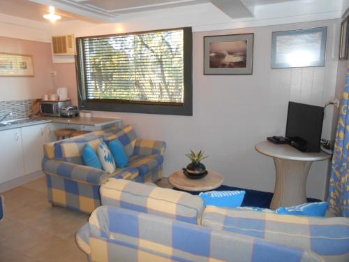 a living room with two couches and a kitchen at Mount View Motel in Bulahdelah