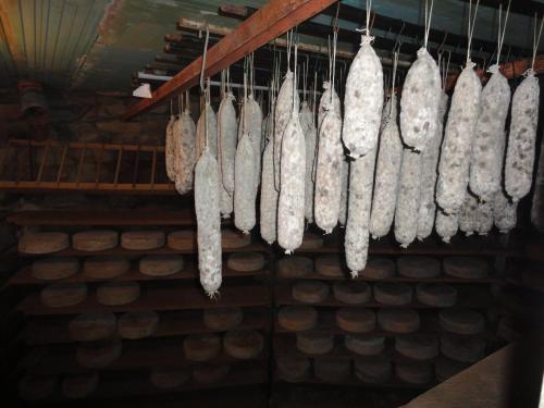 a bunch of meat hanging from a rack in a store at Agriturismo Stella Orobica in Albosaggia