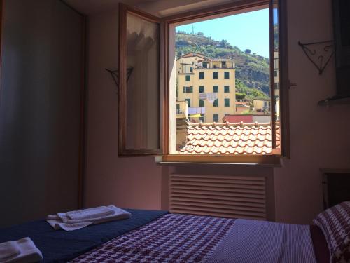 a bedroom with a window with a view of a building at Appartamento chic Riomaggiore 5 Terre in Riomaggiore