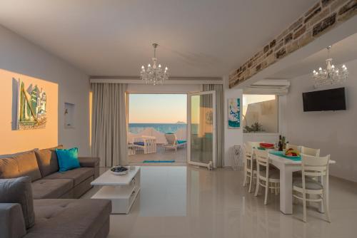 ein Wohnzimmer mit einem Sofa und einem Tisch in der Unterkunft Aristodimos Luxury Apartments in Kalamaki