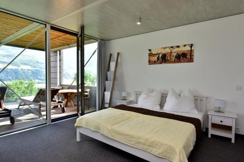 sypialnia z dużym łóżkiem i balkonem w obiekcie Glas House - Design Holiday Home w mieście Piesendorf
