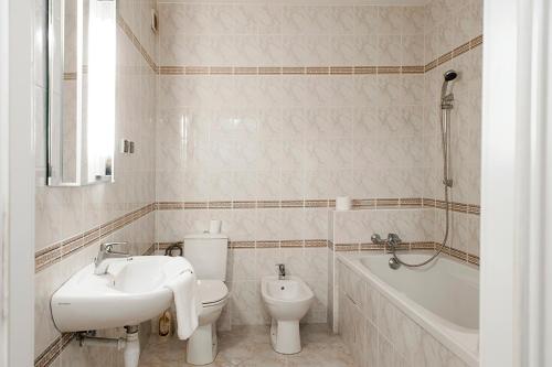 a bathroom with a sink and a toilet and a bath tub at DOMOTEL Aleje Jerozolimskie in Warsaw