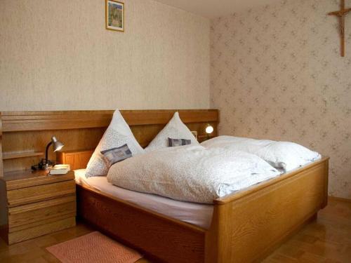 una camera con un grande letto con testiera in legno di Ferienwohnung Bertsche a Villingen-Schwenningen