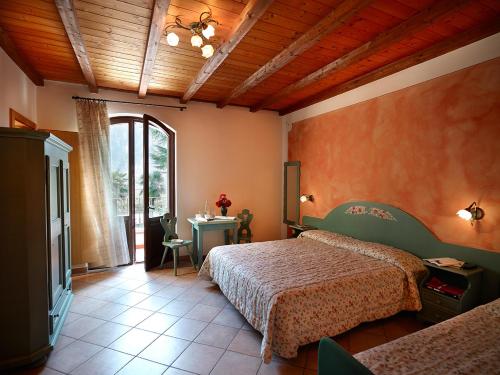 een slaapkamer met 2 bedden en een televisie en een tafel bij Agriturismo Roeno in Belluno Veronese