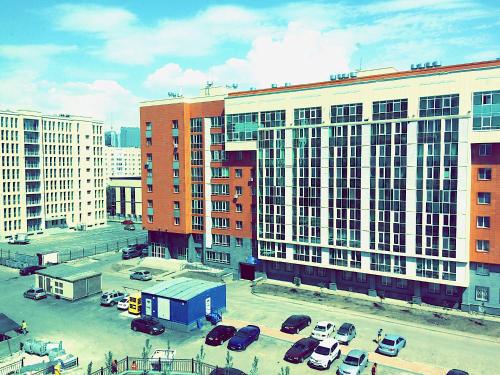 un parking avec des voitures garées devant les bâtiments dans l'établissement Vesna Apartments in the Center, à Astana