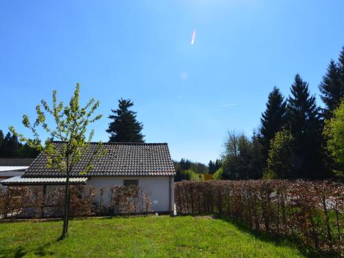 uma pequena árvore num quintal ao lado de um edifício em Absolute holiday house at the edge of the forest em Leideneck