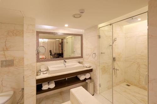 y baño con lavabo y ducha. en Samanvay Boutique Hotel en Udupi