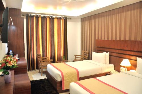 Postel nebo postele na pokoji v ubytování Hotel SGT Plaza