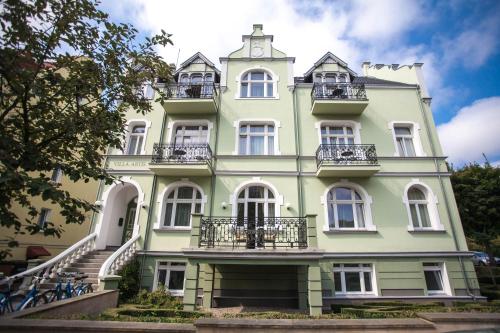 a large green building with stairs in front of it at Apartamenty Villa Artis in Świnoujście