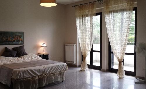a bedroom with a bed and large glass doors at Appartamenti in Villa incanto dei trabocchi Un gioiello esclusivo tra mare e natura in Treglio