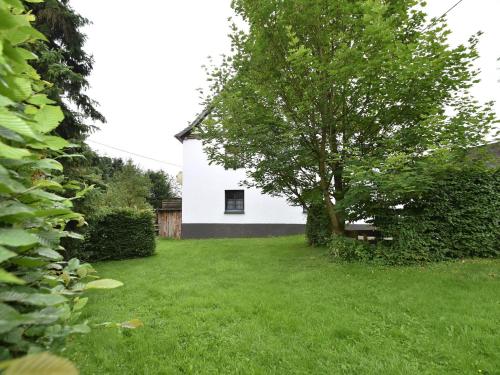 una casa blanca con un árbol en un patio en Spacious Holiday Home in Menkhausen near Ski Area, en Schmallenberg