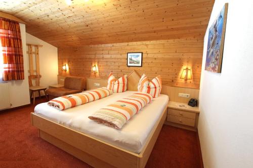 ペットイ・アム・アールベルクにあるAppartements Zangerleの木製の部屋に大型ベッドが備わるベッドルーム1室が備わります。
