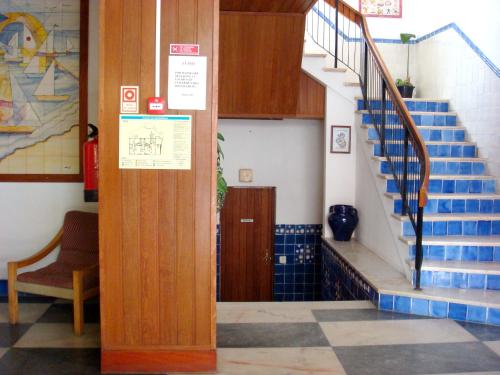 eine Treppe in einem Gebäude mit blauen und weißen Fliesen in der Unterkunft Residencial Habimar in Sines