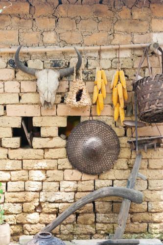 a stone wall with a cow skull and horns and a basket at Rural House in Yangshuo