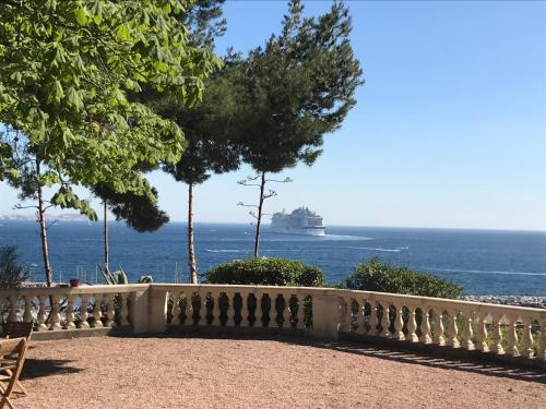 a cruise ship in the ocean behind a fence at Maison d'Hôtes La Bastide Bleue in Marseille